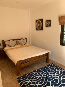 um quarto com uma cama e um tapete em SUNRAY Guesthouse สุนันท์บ้านพักริมคลอง em Uthai Thani