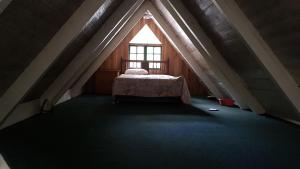 a attic room with a bed and a window at Silver Hill Select in Spa Spring