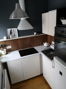 a kitchen with white cabinets and a stove top oven at Przytulna Kawalerka w Kamienicy in Olsztyn