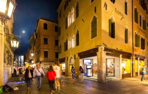 a group of people walking down a street at night at BW Premier Collection CHC Continental in Venice