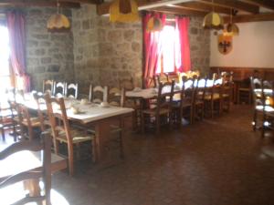 a dining room with tables and chairs and windows at Hôtel La Randonnée in Nasbinals +17 photos