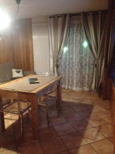 mesa y sillas en una habitación con ventana en Casa Alfredo en Cogne