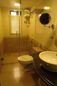 a bathroom with a toilet and a shower and a sink at Jyoti Dwelling Hotel in Mumbai