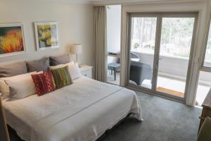 Un pat sau paturi într-o cameră la Elfin Hill Vineyard Accommodation
