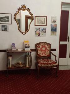 a room with a chair and a mirror on the wall at Family Hotel Balbi in Genoa