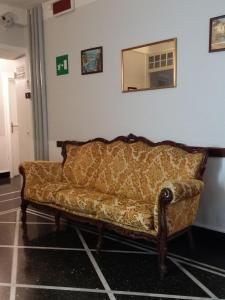 a couch sitting in a room with a mirror at Family Hotel Balbi in Genoa