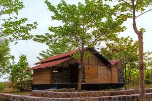mały domek z drzewem przed nim w obiekcie Maati Jungle Lodge Resort Bandhavgarh w mieście Tāla