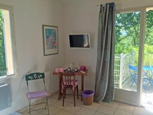 Pokój ze stołem, krzesłami i oknem w obiekcie Les Restanques w mieście Goult