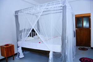 1 dormitorio con cama con dosel y mosquiteras blancas en Sea sound cabana & Restaurant, en Tangalle