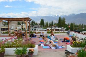 a group of people doing yoga on a patio at Hotel Lingzi in Leh