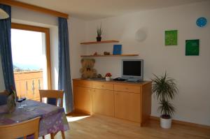 Kaserhof في بريسانون: غرفة معيشة مع تلفزيون على خزانة خشبية