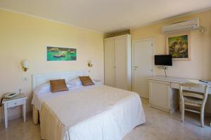 a bedroom with a bed and a desk and a computer at Hotel Seggio in Vieste