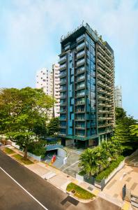 a tall blue building with trees in front of it at Oakwood Studios Singapore in Singapore