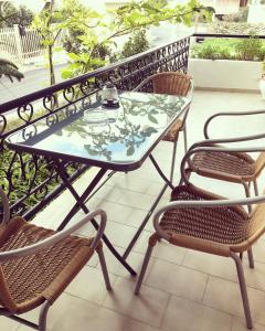 a glass table and chairs on a balcony at Evripides Vintage Airport in Spata