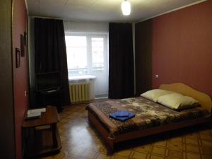 a bedroom with a bed and a window and a television at Apartments BastiON in Kyzyl