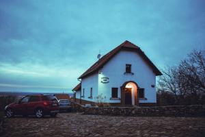 a white house with a car parked in front of it at Penzión nad Skalicou in Skalica