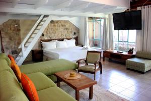 ロシュ・ピナにあるPina Balev Innのベッドとリビングルームが備わるホテルルームです。