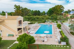 vista aerea su una piscina del resort con sedie e ombrelloni di Oliveland Apartments a Kávos