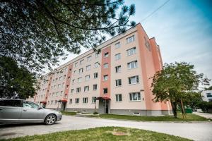 a car parked in front of a large building at A.H Tammsaare Pärnu Apartment in Pärnu