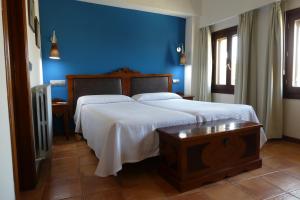 1 dormitorio con 1 cama grande y pared azul en Hospederia de Loarre, en Loarre