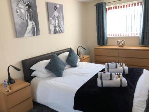 um quarto com uma cama com lençóis brancos e almofadas azuis em Castle Gait, Paisley em Paisley