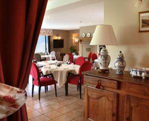 Hotel du Moulin aux Draps في Desvres: غرفة طعام مع طاولة وكراسي حمراء
