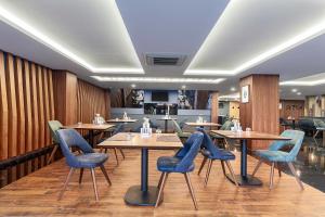 un ristorante con pareti e tavoli in legno e sedie blu di Park Dedeman Trabzon a Trabzon