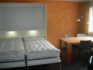 sypialnia z łóżkiem i stołem z krzesłami w obiekcie Brüggli A14 w mieście Arosa
