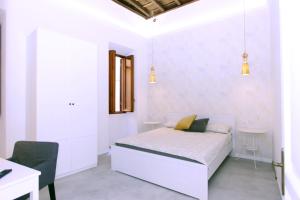 a white bedroom with a bed and a desk at Monte Giordano Flats in Rome