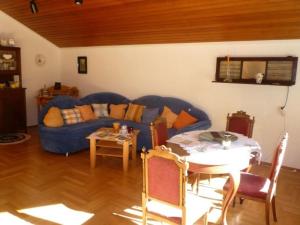 a living room with a blue couch and a table at Land des Friedens in Nettersheim / Eifel in Nettersheim