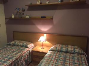 a bedroom with two beds and a lamp on a night stand at Florazar de Ensueño in Cullera +33 photos