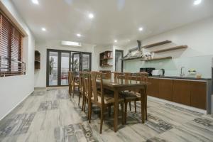 a kitchen and dining room with a wooden table and chairs at HOTEL Blue Rose in Hai Phong