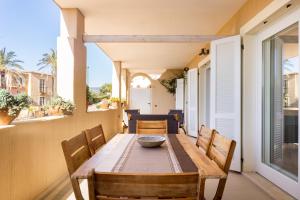 una sala da pranzo con tavolo e sedie sul balcone di Appartamenti Shardana a Villasimius