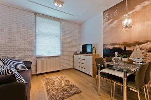 a living room with a dining room table and a couch at Dream Apartments- Balticana in Sopot