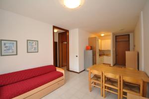 a living room with a red couch and a table at Condominio Delfino in Bibione