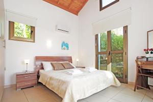 a white bedroom with a bed and a piano at Villa Louisa in Ayia Napa