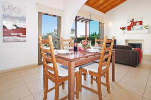 a dining room with a wooden table and chairs at Villa Louisa in Ayia Napa