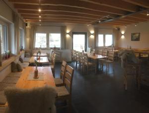 una sala da pranzo con tavoli e sedie in legno di Dorf Alm Ferienwohnung a Schwalmtal