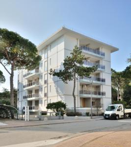 a white apartment building with a van parked in front of it at Condominio Delfino in Bibione