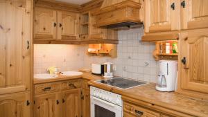 una cucina con mobili in legno e un lavello di Appartment Eichhorn a Sankt Anton am Arlberg
