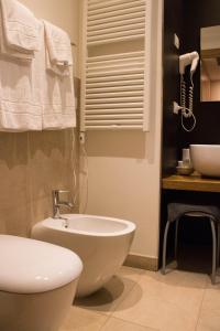 y baño con aseo blanco y lavamanos. en Country Hotel Le Querce, en Salsomaggiore Terme