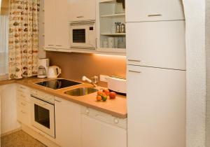 una cucina bianca con lavello e frigorifero di Appartment Eichhorn a Sankt Anton am Arlberg