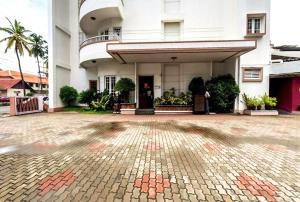 a large white building with a brick driveway at Grand Hotel in Cochin