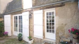 a house with white doors and flowers on it at La Soubeyranne in Mende