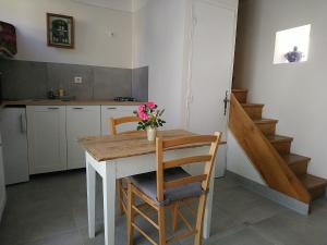 - une cuisine avec une table et 2 chaises fleuries dans l'établissement La Soubeyranne, à Mende