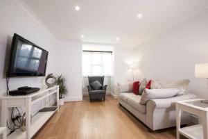 un soggiorno bianco con divano e TV di High Hedges Apartment C a Oxford