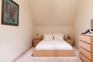 a bedroom with a white bed and two night stands at Lacul Verde Resort in Ploieşti