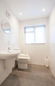 a white bathroom with a sink and a toilet at High Hedges Apartment B in Oxford