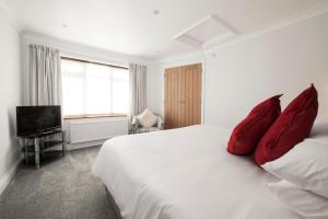 a bedroom with a large white bed with red pillows at High Hedges Apartment B in Oxford