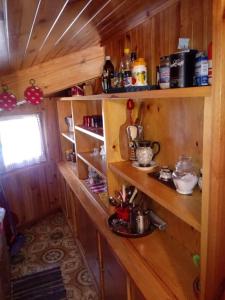 una cocina con paredes de madera y estanterías en una cabaña en Tra sogni e realtà Roccaraso, en Roccaraso